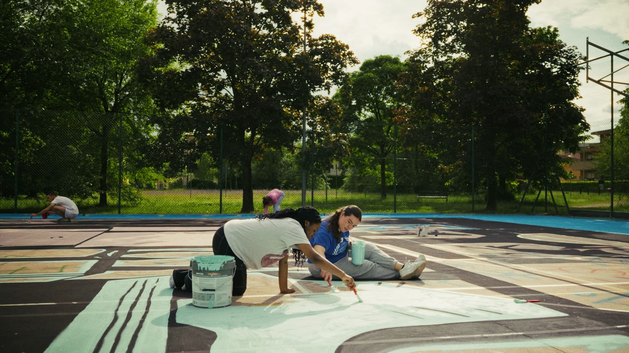 Volunteers painting a playground court together
